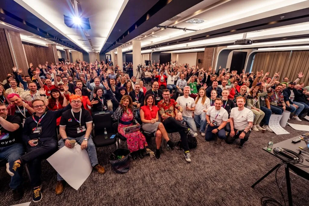 The ColorCloud team on stage with a colorful audience at the conference